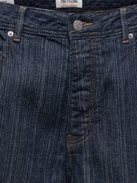 Taille de jean en denim bleu foncé avec des fines rayures blanches verticales, bouton argenté, couture orange, passants de ceinture et une étiquette en tissu visible à l'intérieur de la ceinture.