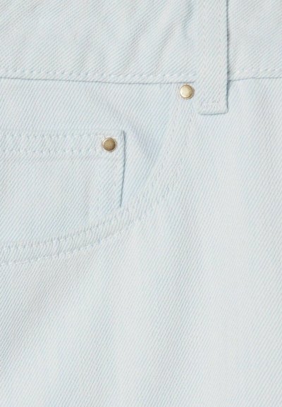 Tessuto di denim blu chiaro con due rivetti metallici dorati, patttern a trama diagonale e un bordo cucito vicino all'apertura di una tasca.