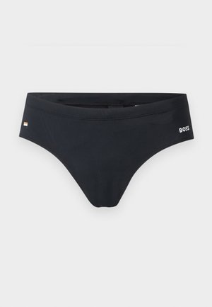 Schwarze Herren-Schwimmslips mit „BOSS“-Logo an der rechten Hüfte und einem kleinen rechteckigen Flaggen-Detail auf der linken Seite.