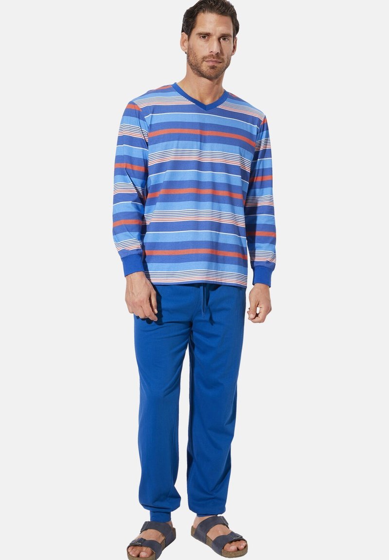 Long-sleeve striped shirt in blue, white, and coral; paired with blue pants; wearing grey sandals; smooth fabric with a relaxed fit.