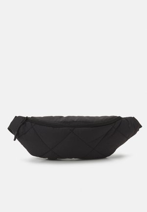 Riñonera negra de tela acolchada con un bolsillo frontal con cremallera y correa ajustable sobre fondo blanco.