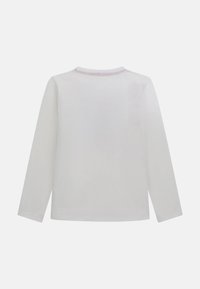 Camicia bianca di cotone a maniche lunghe con scollatura rotonda e cuciture rosa lungo il colletto. Tessuto liscio e senza motivi visibili.