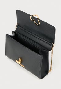 Μαύρο δερμάτινο κλατσ με χρυσό εξοπλισμό. Διαθέτει κούμπωμα σε σχήμα καρδιάς, πολλαπλές θήκες και λουρί από αλυσίδα για ευελιξία.