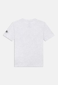 T-shirt a maniche corte grigio chiaro con un piccolo logo Nike nero sulla manica sinistra, vista posteriore su sfondo bianco.