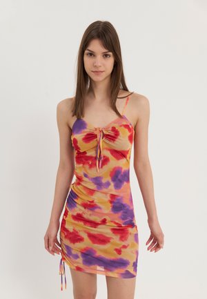 Fargerik tie-dye kjole med tynne stropper, i nyanser av rødt, oransje, lilla og gult. Rynkede detaljer med justerbare bånd i fallen.