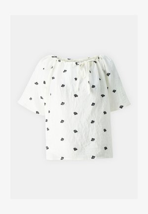 Valge, vabalt langev pluus lühikeste varrukatega, musta lillebordüüri ja kummipaela kaelusega, valmistatud kergest kangast.