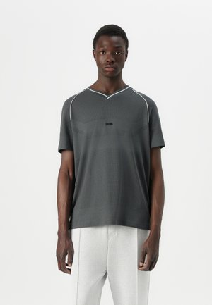 Grey short-sleeve V-neck T-shirt with a textured pattern, featuring a subtle logo and contrasting trim along the neckline and shoulders.