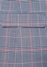 Szaro-biała tkanina w kratę z niebieskimi i czerwonymi liniami, o gładkiej teksturze i subtelnym połysku. Zawiera poziomy detal kieszeni.