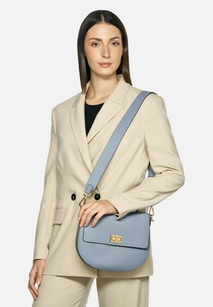 Sac bandoulière en cuir bleu clair avec une surface texturée, une forme arrondie, des garnitures dorées et une bandoulière réglable.