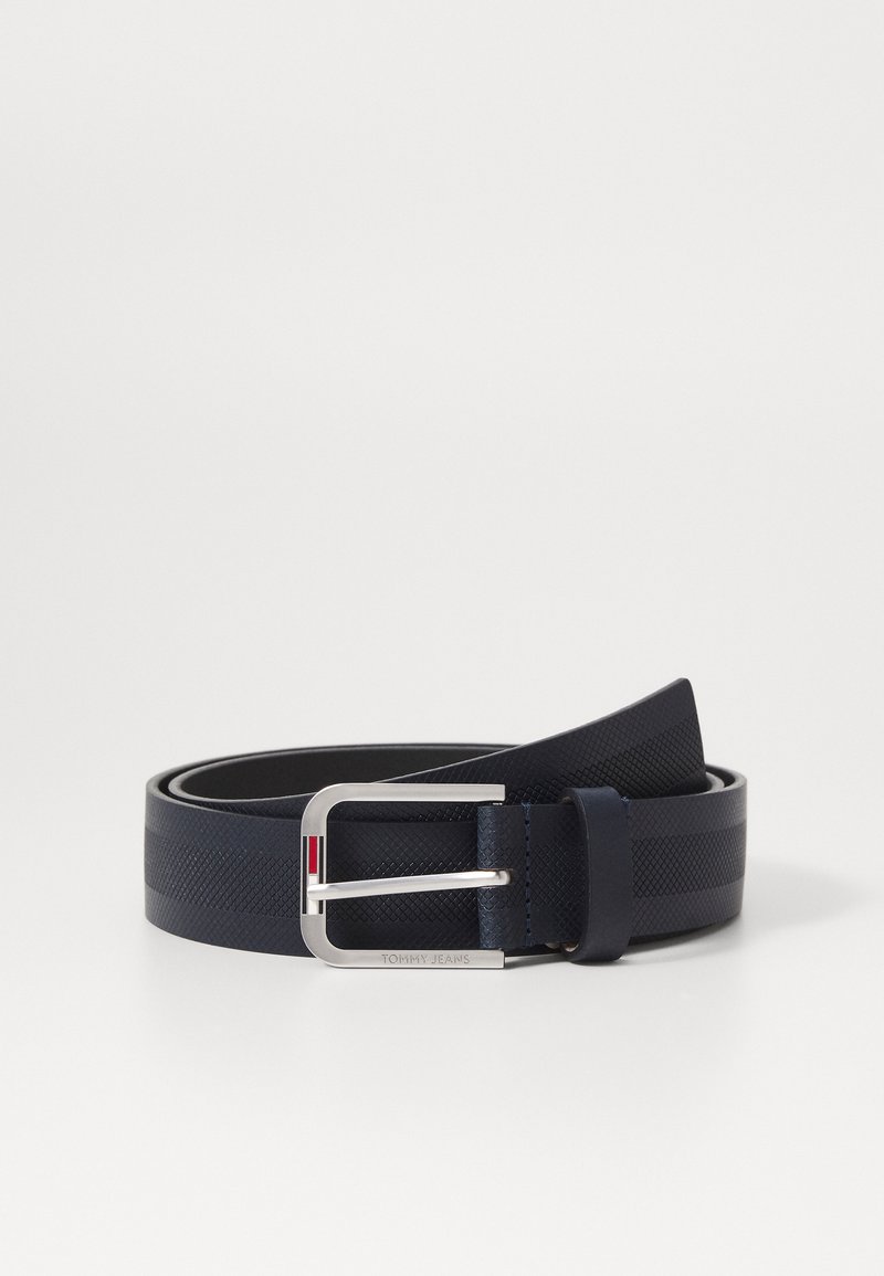 Cinto azul-marinho feito de material sintético texturizado, com uma fivela prateada que tem um pequeno detalhe vermelho e branco e o logotipo da marca em relevo.