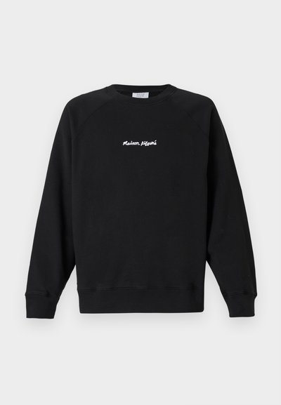 Hanorac negru cu mâneci lungi și guler rotund, cu text alb „Maison Kitsuné” centrat pe piept, prezentat pe un fundal deschis simplu.