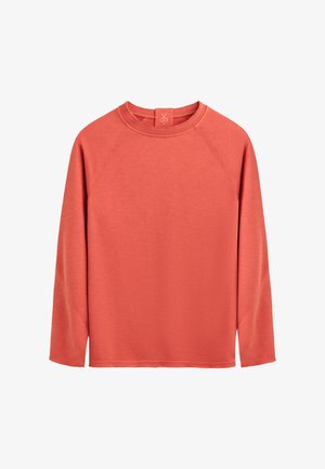 Koraalkleurige pullover met lange mouwen en raglanmouwen, ronde hals en zachte textuur. Voorzien van een achterlabel en een rechte zoom.
