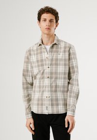 Camicia a quadretti chiara nei toni beige e verde, maniche lunghe, chiusura con bottoni, con bottoni in legno e un piccolo logo sul petto.
