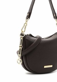 Bruine leren handtas met een ronde vorm. Beschikt over een textuur oppervlakte, gouden hardware en een afneembare schouderband. Minimalistisch ontwerp met logo-accent.