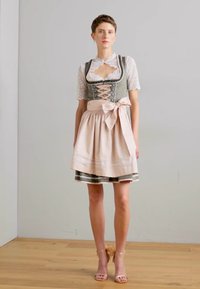 Tradicionalna nemška dirndl obleka z zelenim korzetom in čipkastim prekrivalom, roza krilom z detajlom mašne in svetlimi lesenimi platformskimi petami.