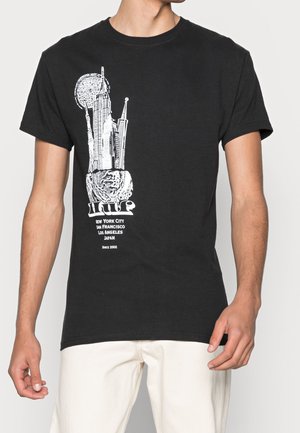 Black t-shirt with white graphic of skyscrapers, a rose, and text naming cities: New York, San Francisco, Los Angeles, Japan.