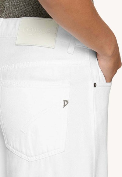 Vita denimjeans med en bakficka med en silvernitat och en vit läderlapp märkt "DONDUP." Slät textur och skräddarsydd passform.