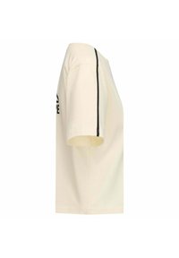 T-shirt di cotone color crema con maniche corte e dettagli neri lungo le cuciture laterali, con un logo stampato sul davanti.