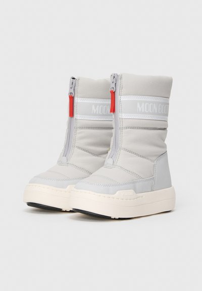 Et par lysegrå polstrede vinterstøvler med frontlynlås, rød trækflap, hvid sål og "MOON BOOT"-branding på den øverste del.