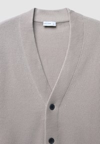Beige geripptes Cardigan mit V-Ausschnitt, ausgestattet mit dunklen Knöpfen und einem strukturierten Muster. Das Etikett trägt die Aufschrift "CALLIOPE" in Größe "L."