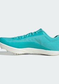 Teal athletic shoe with textured mesh upper, flat white sole, and metal spikes on the outsole for traction. Features lace-up design.