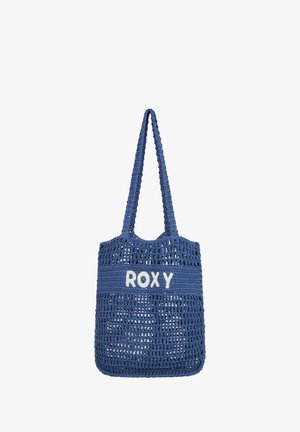 Blauwe geweven draagtas met een effen bovenstuk waarop "ROXY" in het wit staat. Ontworpen met twee stevige handgrepen voor het dragen.