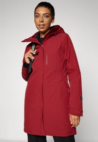 Rød vanntett parka med hette, med glidelås foran, sidelommer og justerbare ermer. Glatt ytre med en funksjonell design.