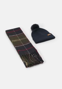Kötött sötétkék sapka pom-pommal és sötét színekkel, vörös és zöld árnyalatokkal díszített kockás sál, az egyik végén rojttal.