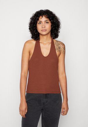 Top halter canelado castanho com decote profundo em V e alças de ombro, combinado com jeans escuros; apresenta uma textura subtil e um design ajustado.