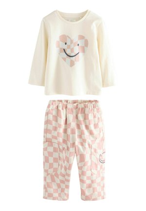 Langarm crème top met hartafbeelding; geruite roze en witte broek met zakken en een glimlachontwerp. Katoenen stof, casual pasvorm.