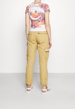 Haut ajusté à manches courtes, multicolore avec motifs célestes ; assorti à un pantalon cargo beige avec deux poches latérales et des poignets réglables.