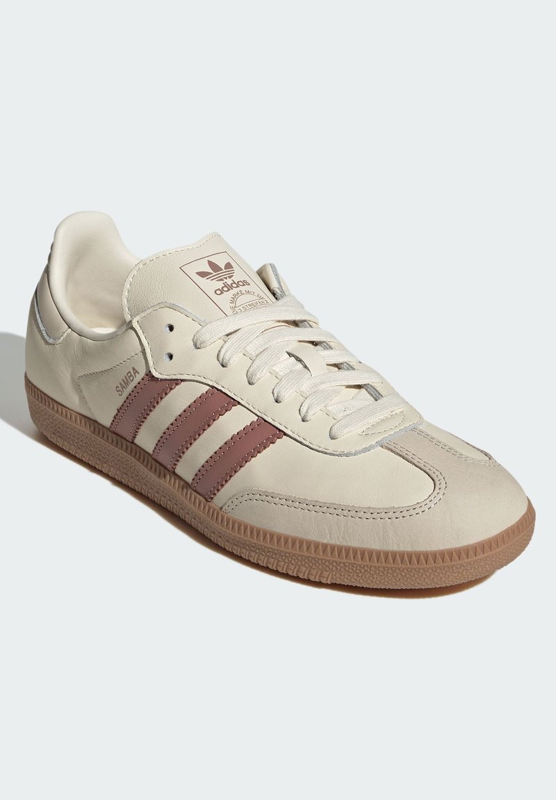 Adidas Samba-skor i krämfärgad läder med bruna tre ränder, snörningsdesign, sula i gummi och stickade detaljer.