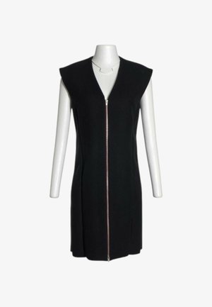 Ärmelloses schwarzes Kleid mit gepolsterten Schultern und einem vorderen Metallreißverschluss, präsentiert auf einem weißen Schaufensterfigur-Torso ohne Kopf oder Hände.