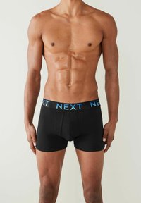 Fekete boxer alsónadrág kék "NEXT" logóval a derékrészen, szoros illeszkedéssel és sima textúrával.