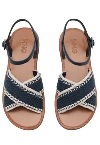 Sandali in tessuto navy intrecciato con design a strappo incrociato, cuciture bianche e suola in gomma marrone. Cinghia alla caviglia regolabile per una vestibilità ottimale.