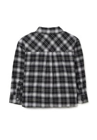 Camicia flanella a quadri bianca e nera con colletto button-down, maniche lunghe e dettaglio di piega sul retro. Texture morbida e motivo a scacchi.