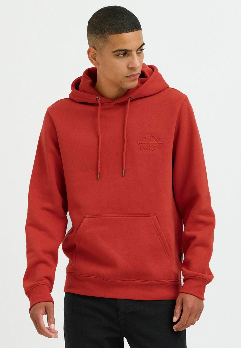 Red hoodie made of soft material, featuring a kangaroo pocket, adjustable drawstring hood, and subtle embossed logo on the chest.