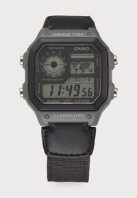 Montre numérique avec un cadran rectangulaire noir et des accents gris. Elle dispose d'un bracelet en cuir noir, de boutons multifonctions et d'un affichage de l'heure mondiale.