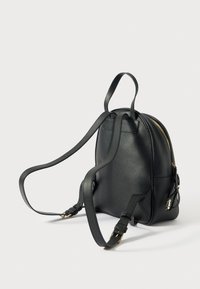 Mochila de cuero negro con forma redondeada, superficie texturizada, correas ajustables y herrajes en tono dorado. Compartimento principal con cremallera y bolsillo lateral.