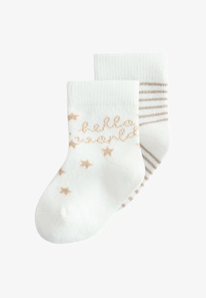 Twee witte babysokjes, één met beige sterren en cursieve tekst, de ander met beige horizontale strepen op de enkel.