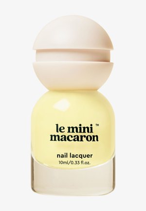 Żółty lakier do paznokci w kulistym szklanym pojemniku z beżową zakrętką. Tekst: "le mini macaron lakier do paznokci, 10ml/0.33 fl. oz."