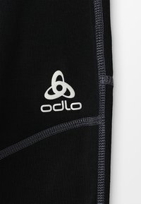 Leggings sportivi neri realizzati in tessuto liscio, con cuciture flatlock grigie a contrasto e un logo Odlo bianco.