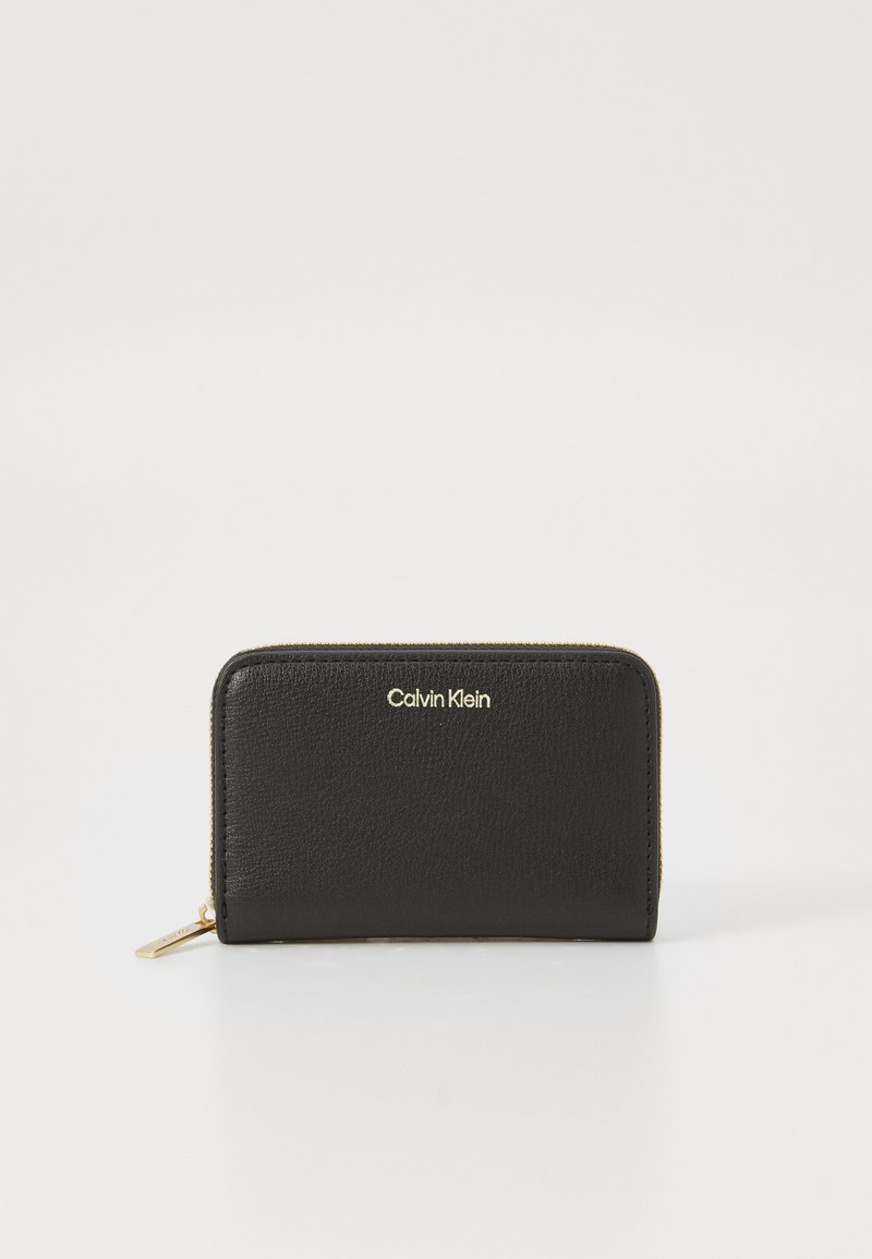 Zwarte leren portemonnee met een gestructureerde afwerking en een gouden rits. De voorkant heeft een subtiel verdiept Calvin Klein-logo. De ritstrekkker is van goudkleurig metaal.