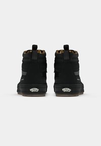 Black waterproof ankle boots with textured fabric, padded collars, rubber soles, and a distinctive logo at the heel. Lined with a leopard print.