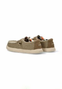 Zapatos de tela trenzada marrón tipo slip-on con suela de yute trenzada beige, presentan un forro interior colorido y cordones decorativos.