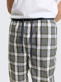Pyžamové nohavice s károvaným vzorom v zelených, bielych a námorníckych farbách, s elastickým pásom, sťahovacou šnúrkou a jedným gombíkom.