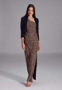 Leopardenmuster-Kleid mit seitlichem Schlitz und schwarzem Overlay mit langen, drei Viertel Ärmeln. Glattes Material, figurbetonte Silhouette, bis zur Mitte des Waden.