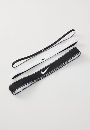 Conjunto de três elásticos para cabelo em preto e branco, com texturas suaves e pequenos logos da Nike. Larguras e designs variados.