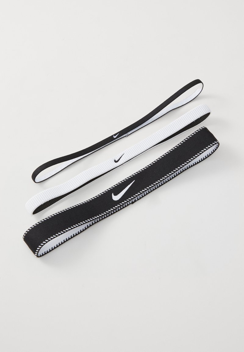 Set di tre elastici per capelli in bianco e nero, caratterizzati da texture lisce e piccoli logo Nike. Larghezze e design variabili.