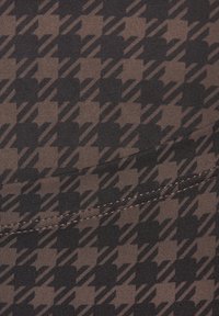 Brown fabric with a houndstooth pattern and diagonal lines. Features a seam along the bottom edge. Smooth texture and elastic material.